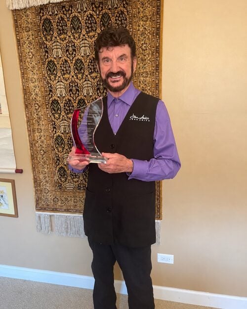 John Amico holding his Enduring Legacy Award